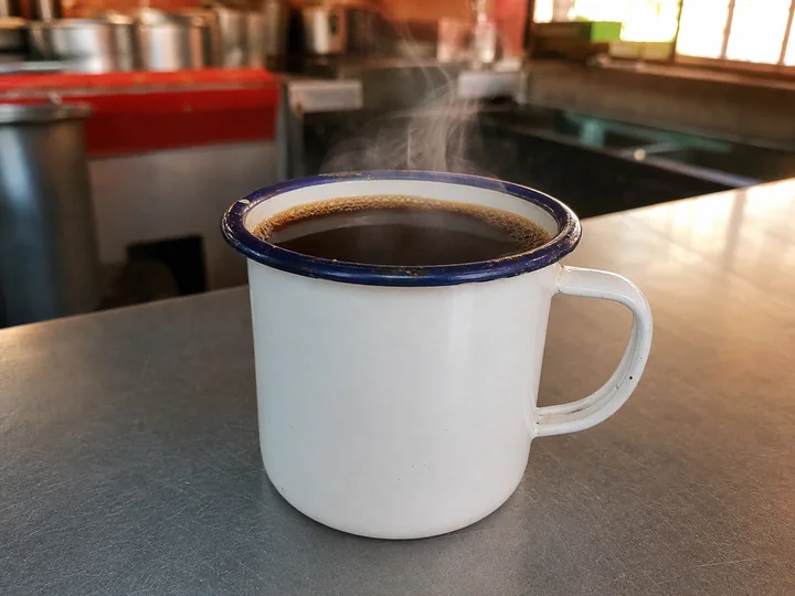 Café de olla caliente servido en una taza de peltre